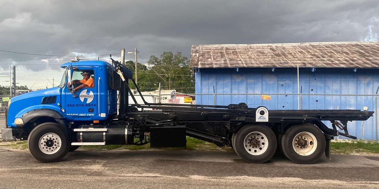 Hoopers driver in blue Mack rolloff truck